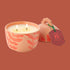 A ceramic orange candle with a lid. 