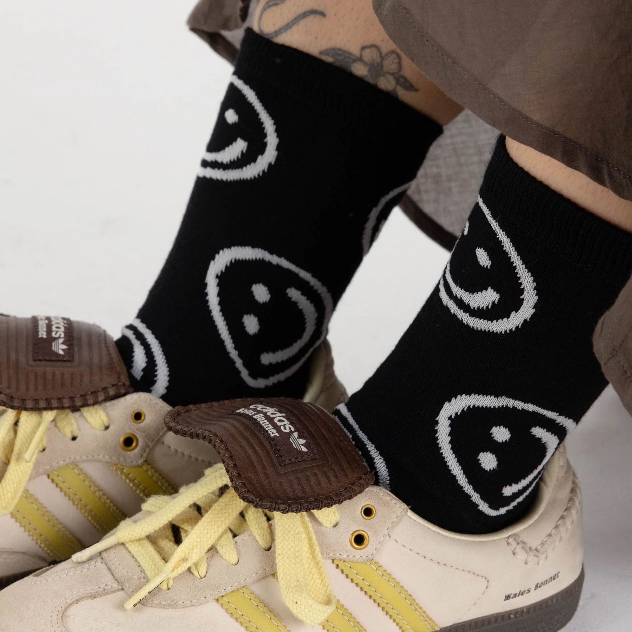 A pair of black socks with white smiley faces on them.