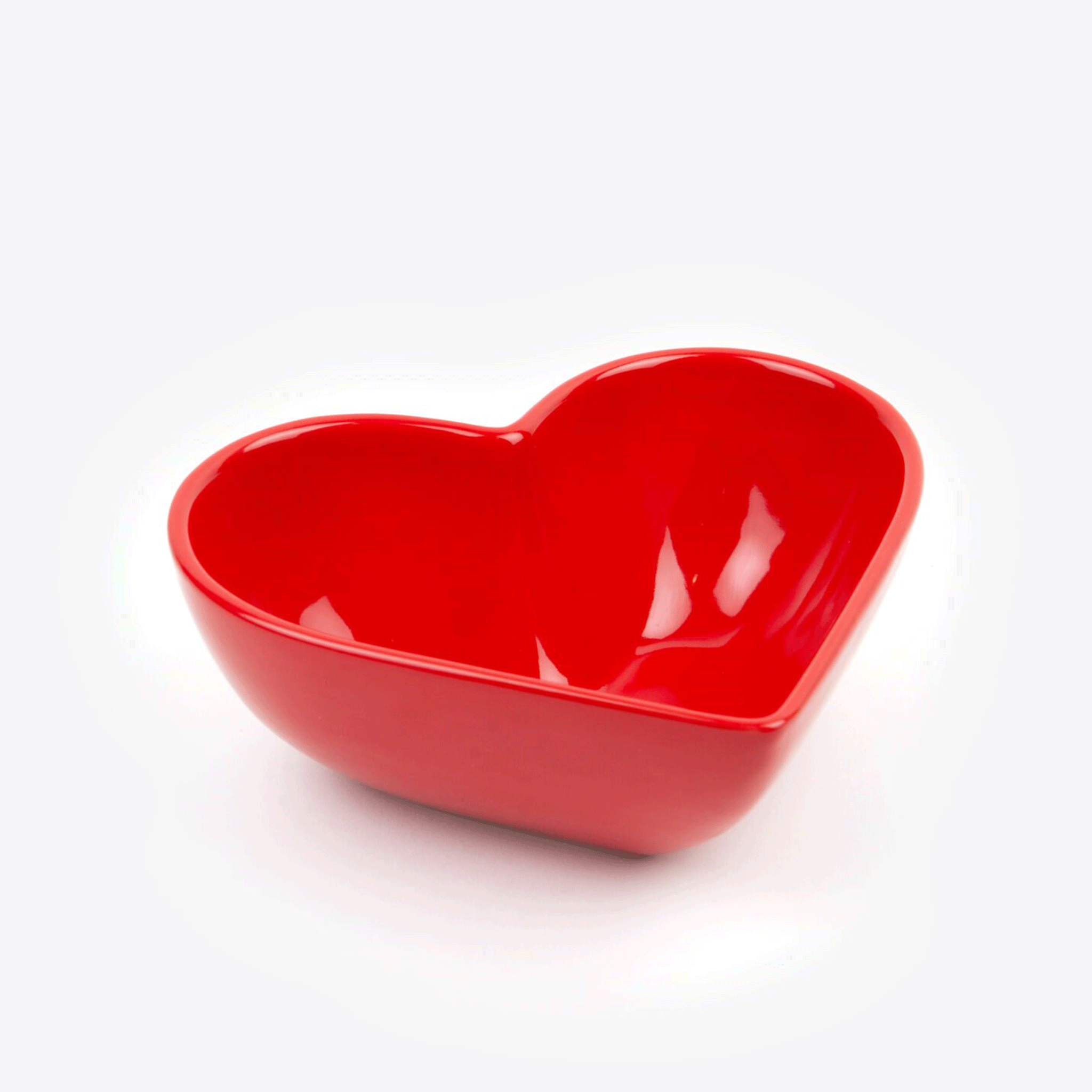 A red ceramic heart shaped bowl. 