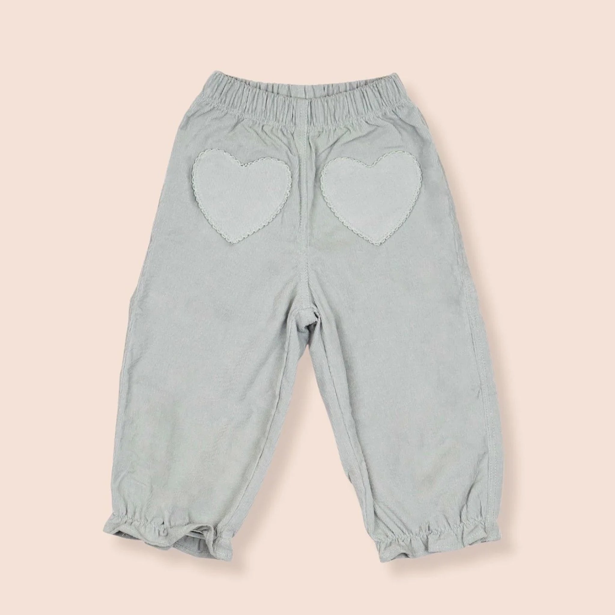 A pair of light blue pants with heart shaped pockets. 