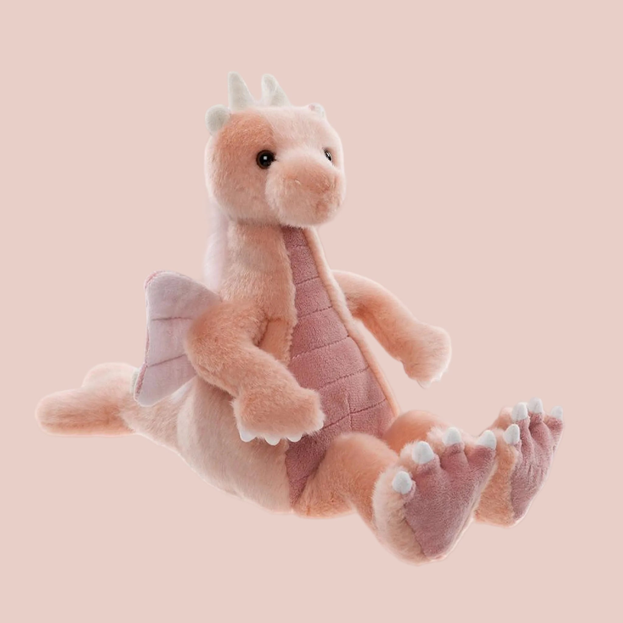 A pink dragon shaped stuffed animal toy. 