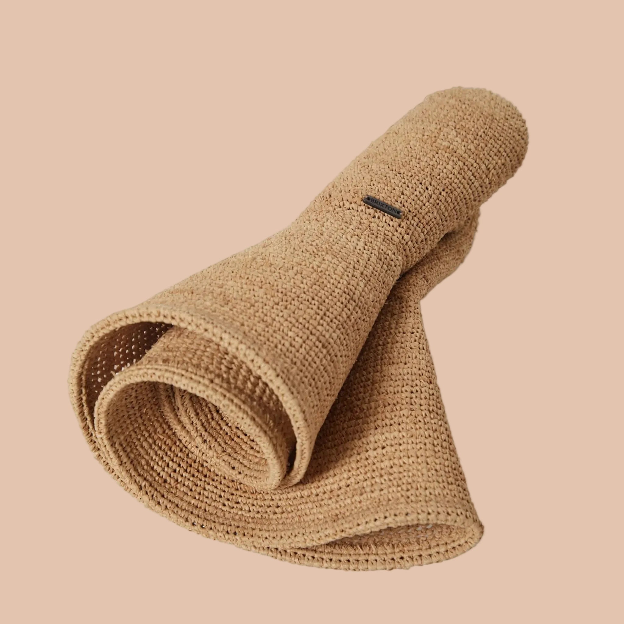A tan straw foldable hat. 