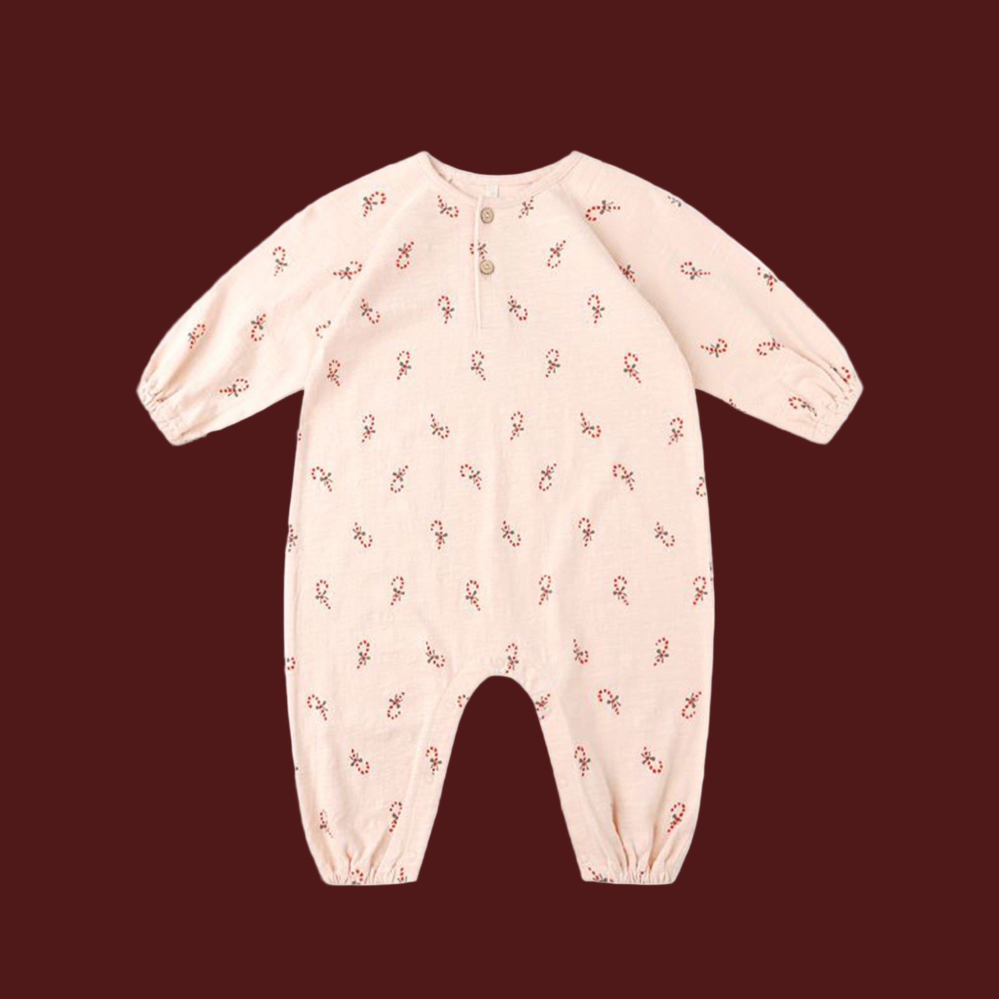 A light pink long sleeve jumpsuit with a candycane print. 