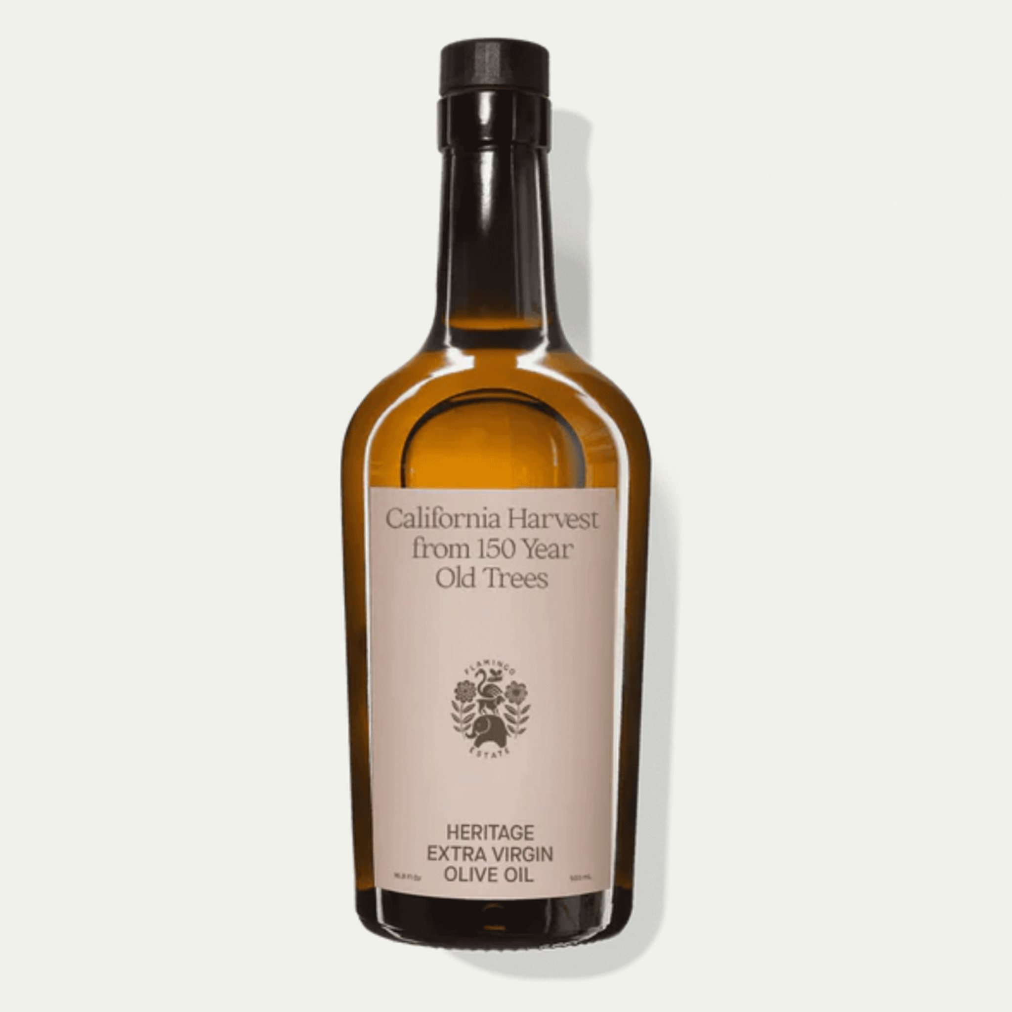 On a white background is a brown glass bottle of olive oil with a label on the front that reads, "California Harvest from 150 Year Old Trees".  