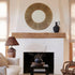 A round mirror with a woven jute edge around the perimeter. 