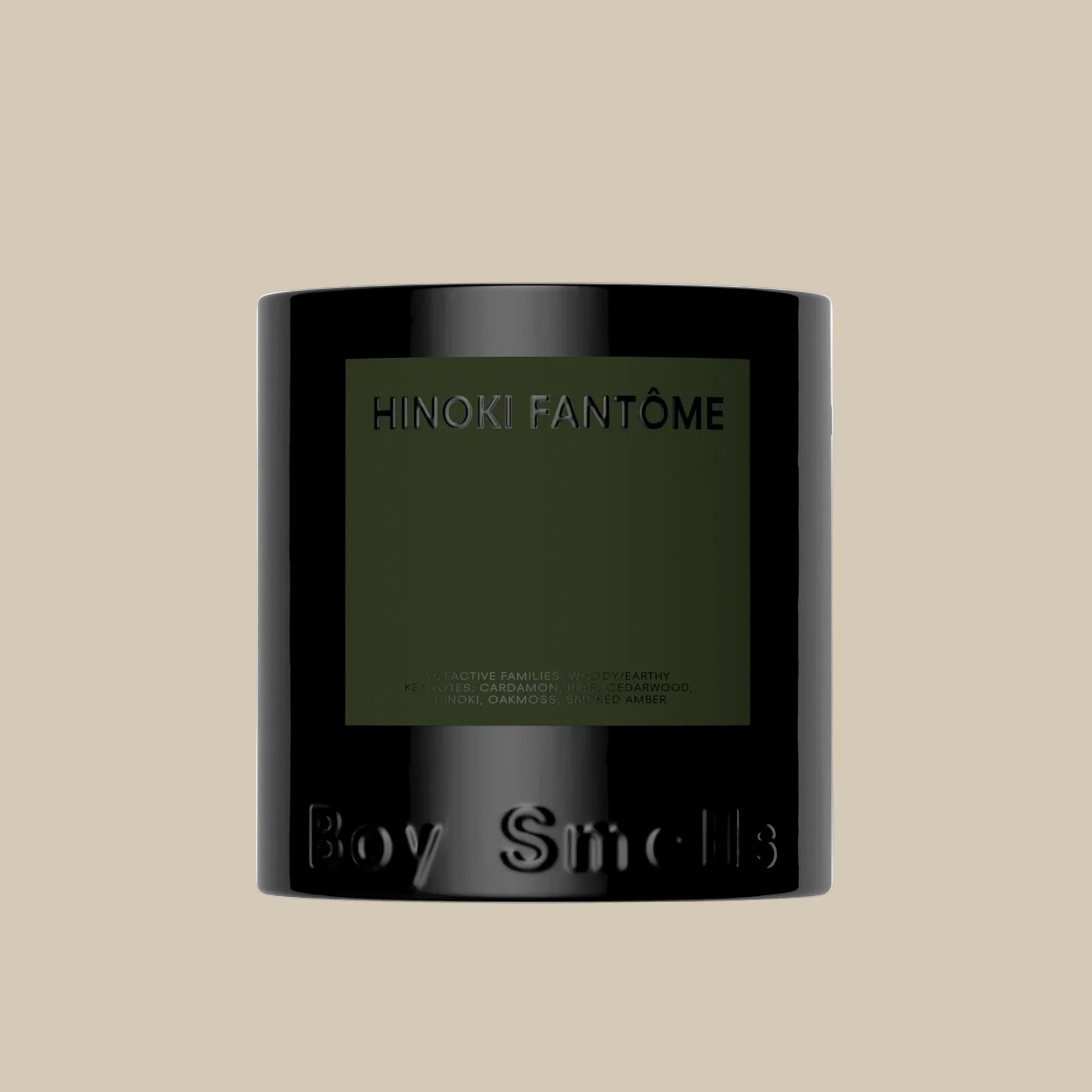 A black jar candle with a green label that reads, 'Hinoki Fantome Boy Smells'. 