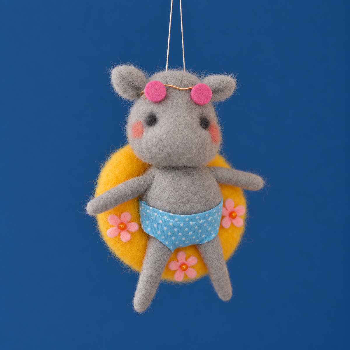 a felt hippo shaped ornament on a yellow pool tube. 
