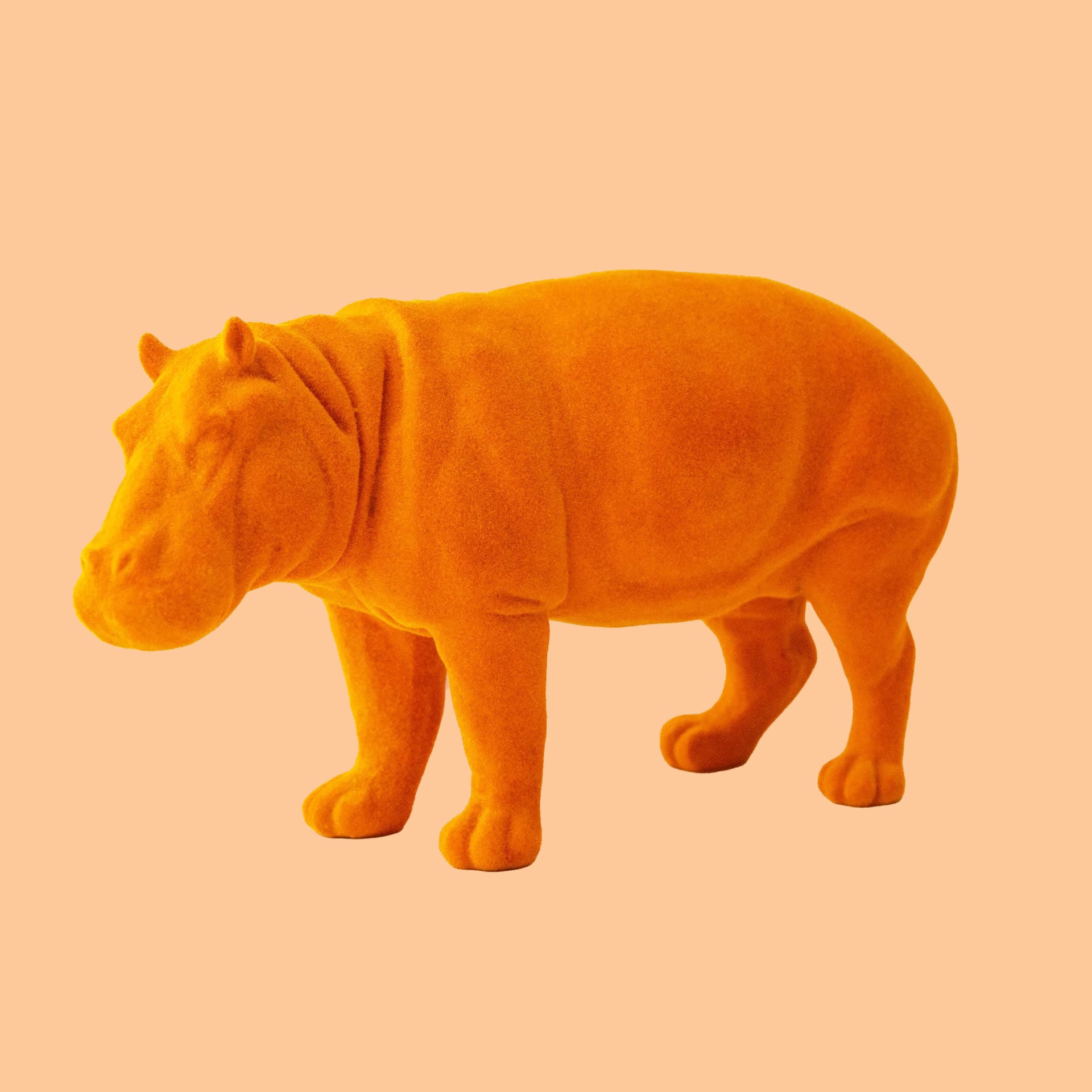 An orange flocked hippo figurine decoration. 