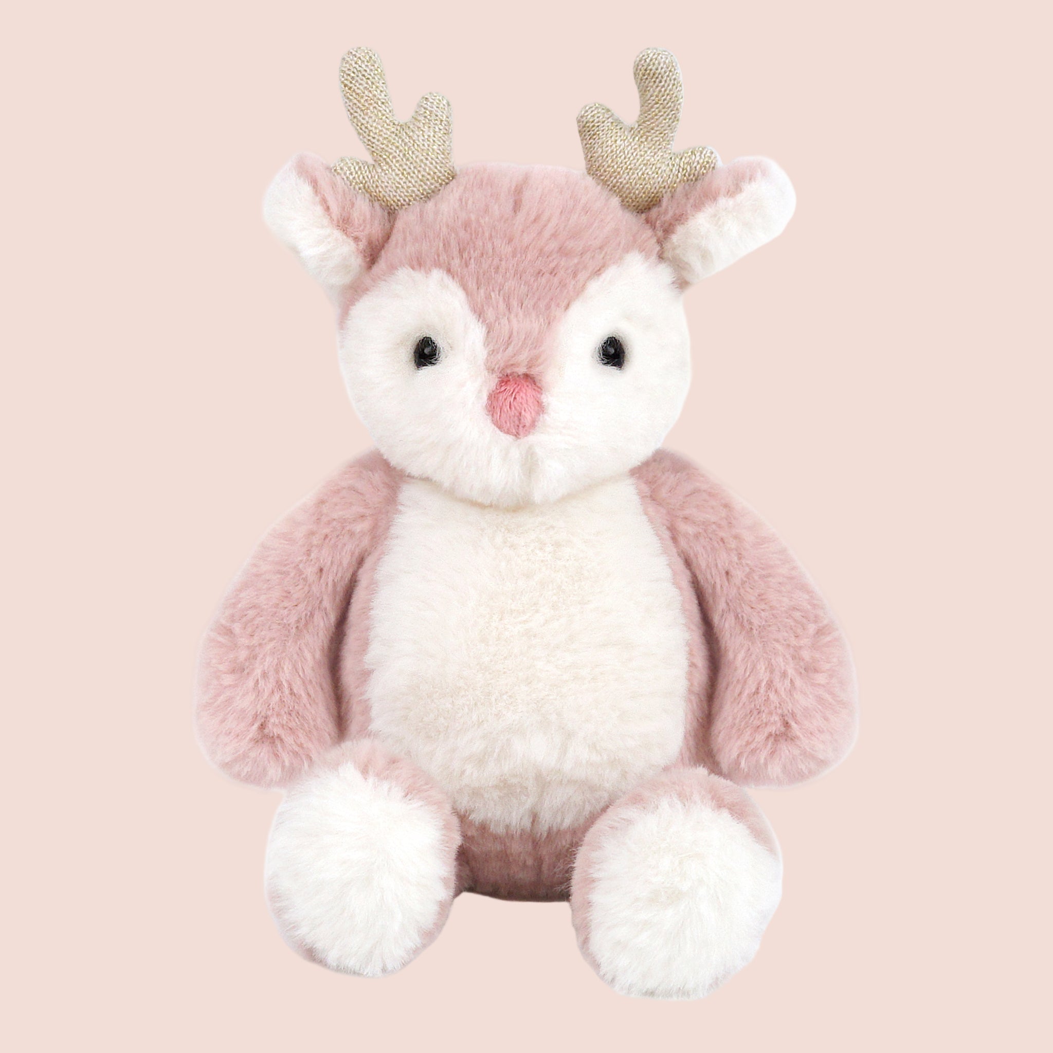 A pink and white reindeer shaped stuffed animal toy. 