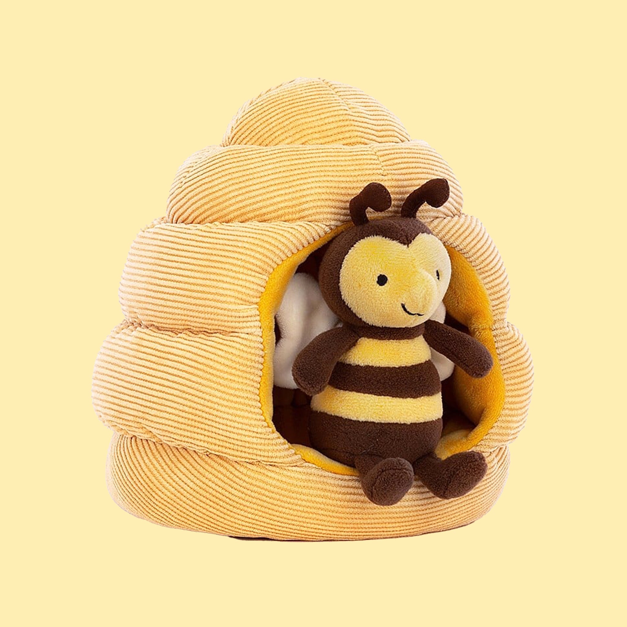 A bee shaped stuffed toy along with a honeybee hive shaped toy. 