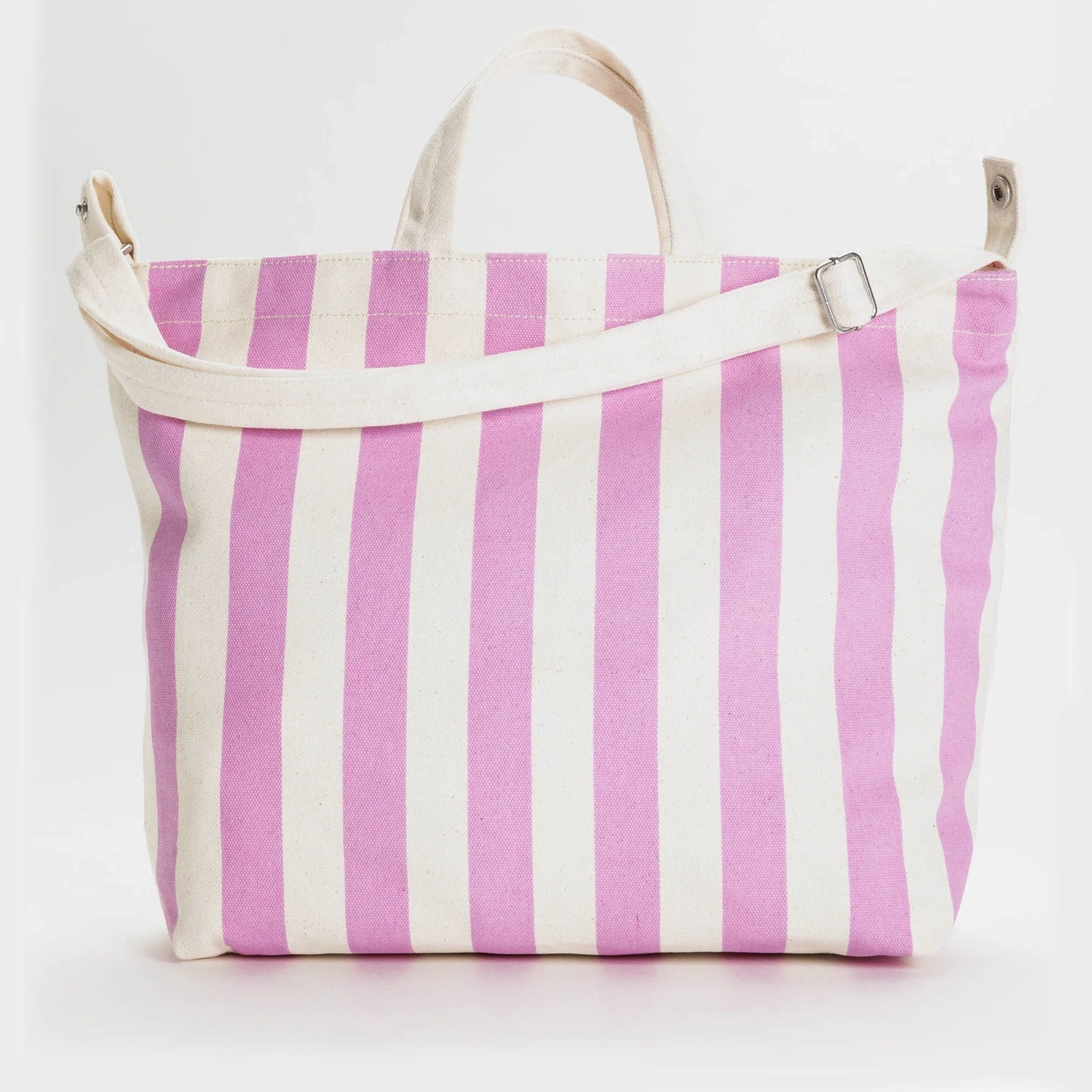 On a white background is a square tote bag with white and hot pink stripes along with two handles and a longer crossbody or shoulder strap. 