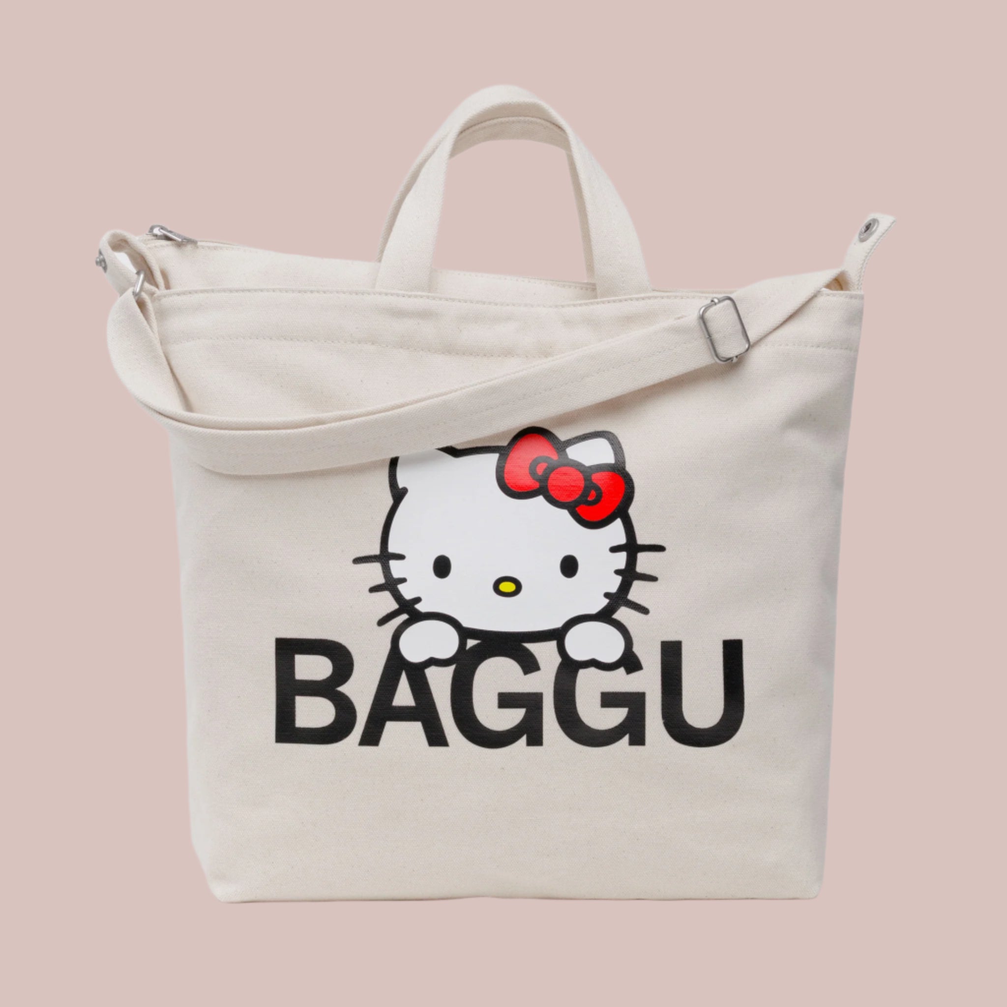 A neutral canvas bag with a shoulder strap and a screen printed Hello Kitty and black BAGGU logo. 