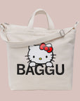 A neutral canvas bag with a shoulder strap and a screen printed Hello Kitty and black BAGGU logo. 