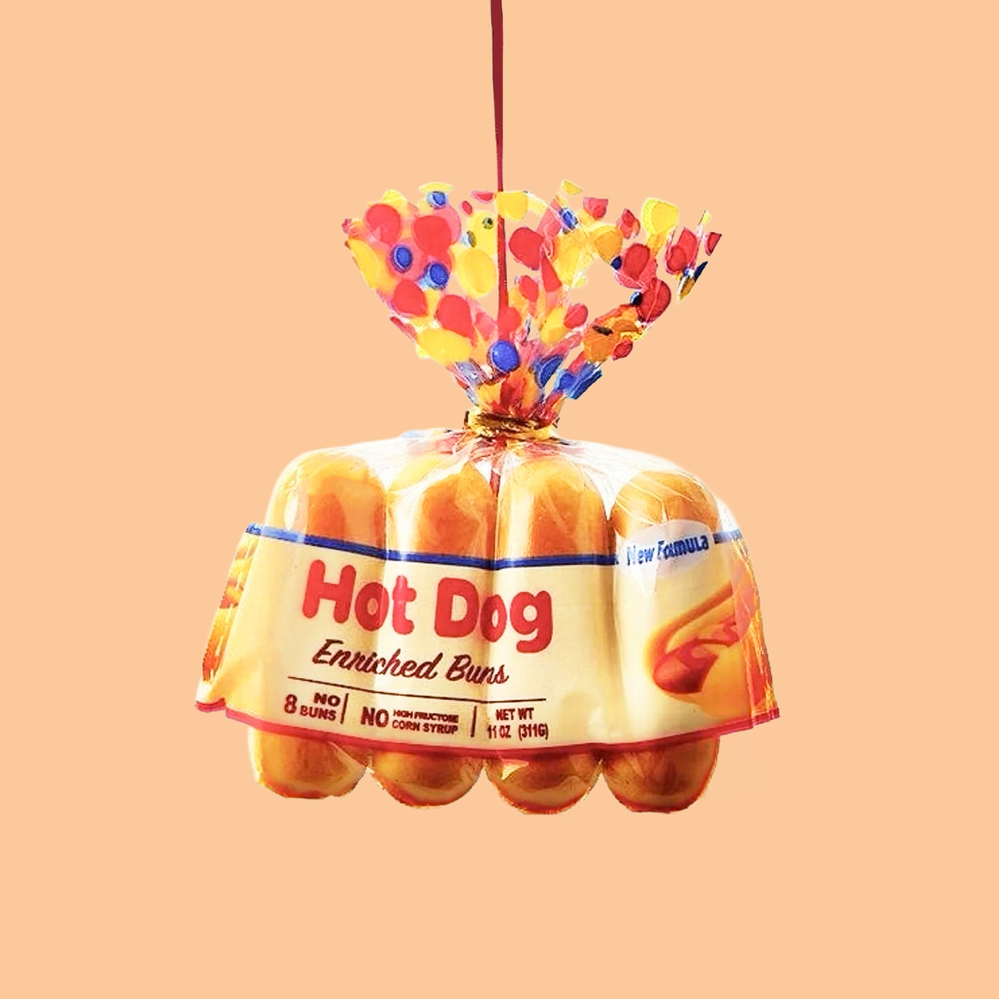 A hot dog buns shaped ornament with a red loop for hanging. 