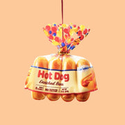 A hot dog buns shaped ornament with a red loop for hanging. 