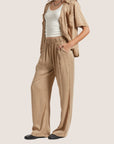 A pair of tan lounge pants with a scrunched waist band. 
