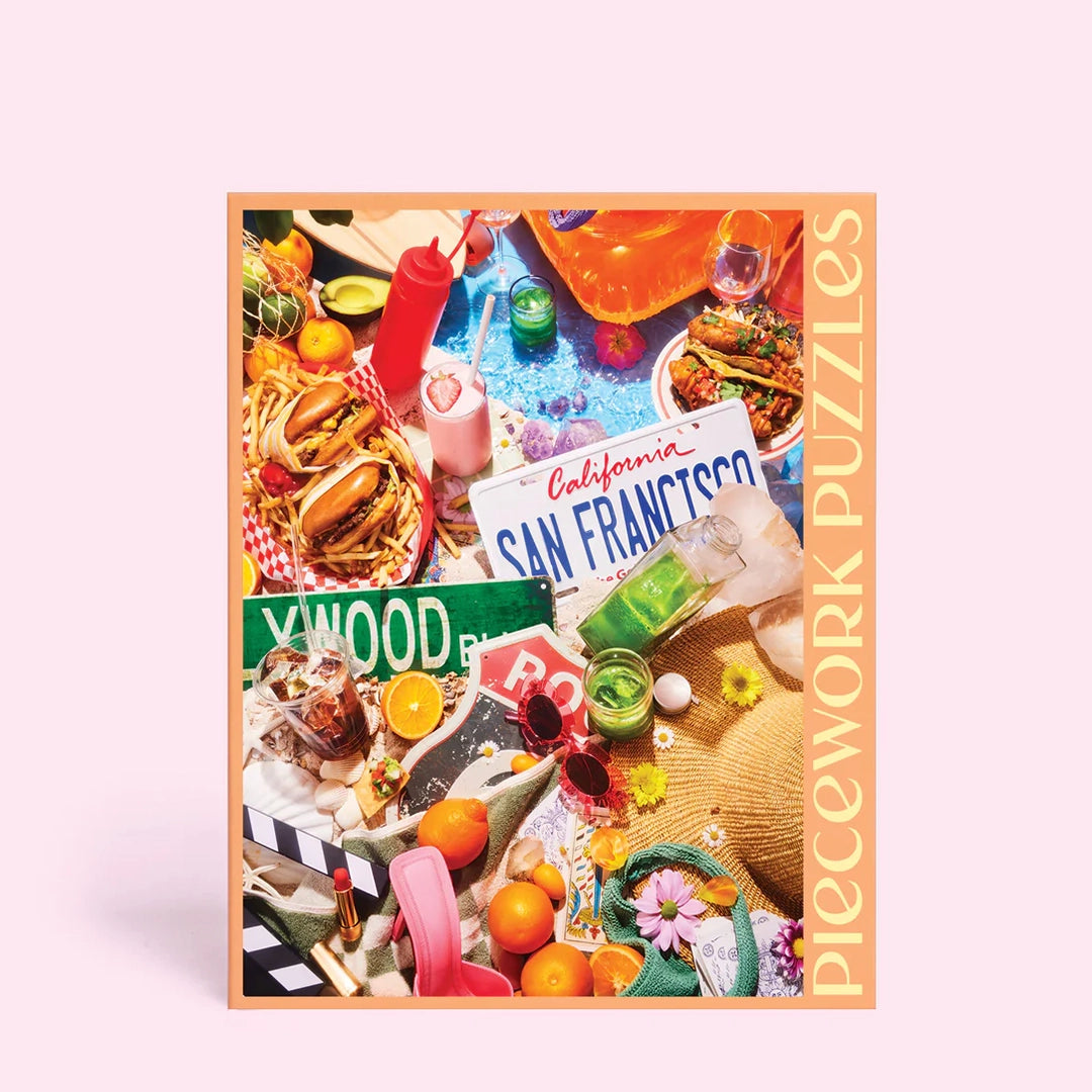 On a light pink background is a puzzle box that has images of the iconic state of California including, green juices, sunglasses, animal style burgers and fries, tacos, a Hollywood street sign and more. 