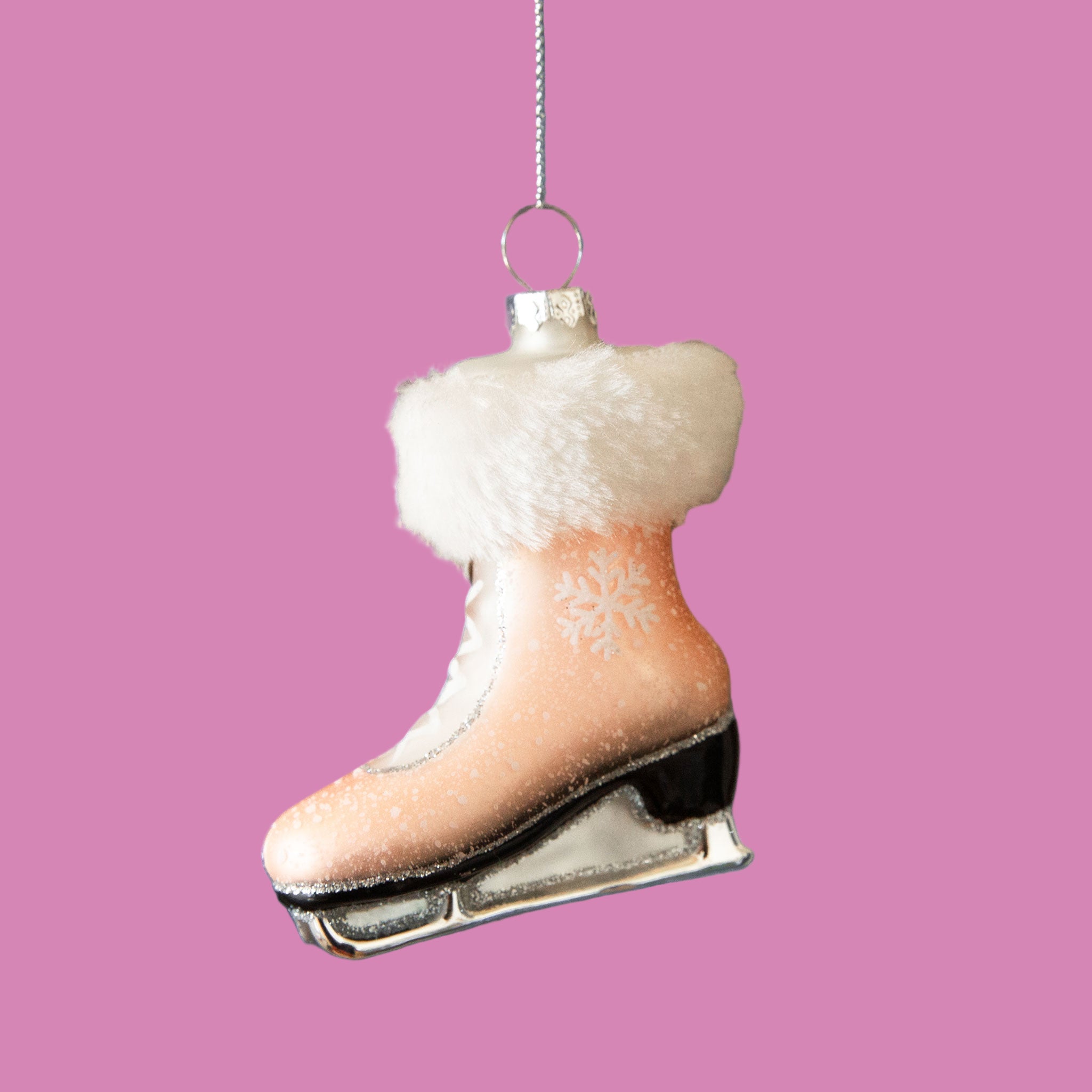 A light pink ice skate shaped ornament with a faux fur trim.