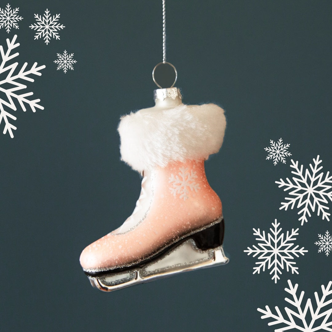 A light pink ice skate shaped ornament with a faux fur trim.
