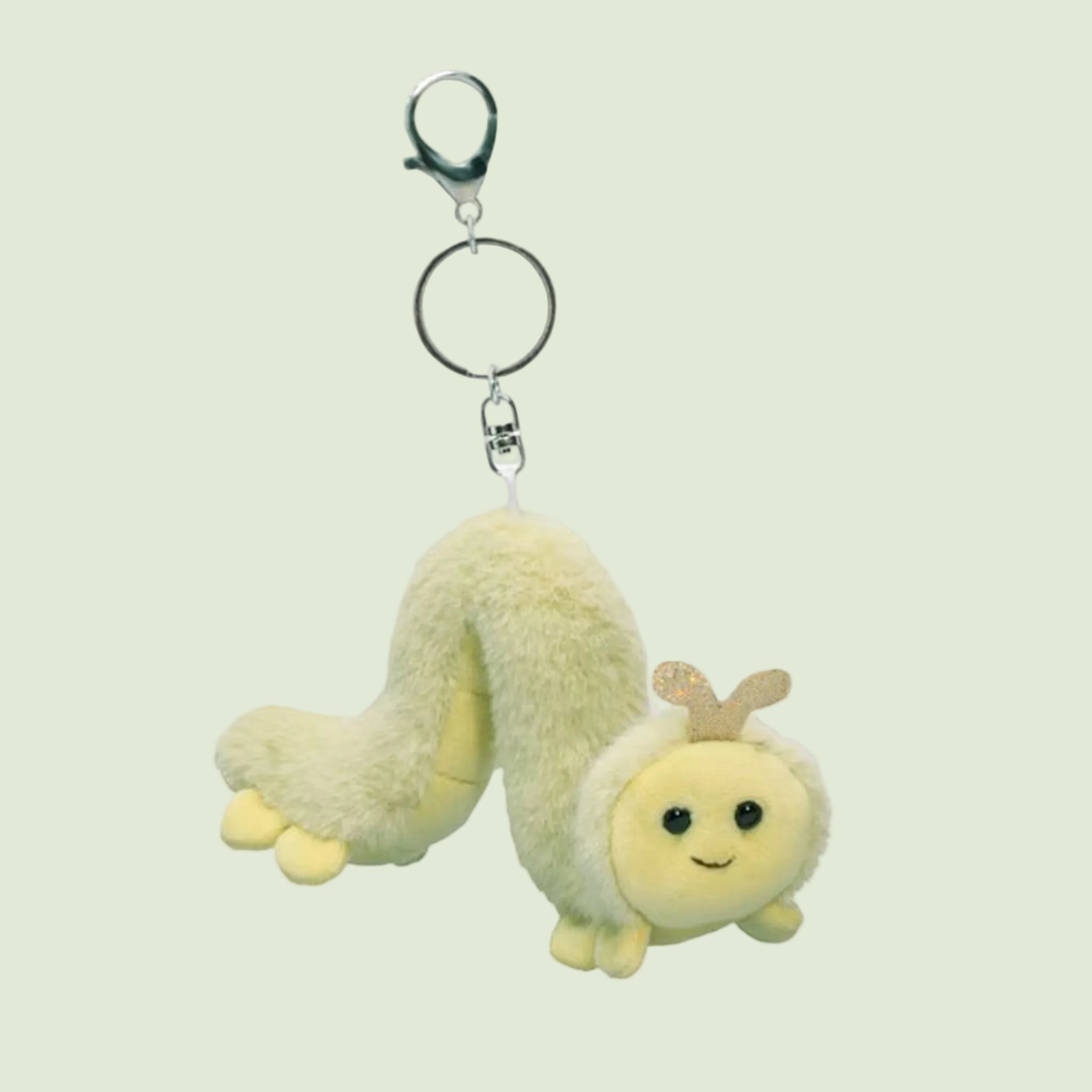 A green inchworm shaped stuffed toy keychain. 