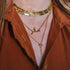 A gold chain necklace with a marquise shaped pendant in the center. 