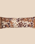 A brown and cream leaf print lumbar pillow with fringe detailing. 