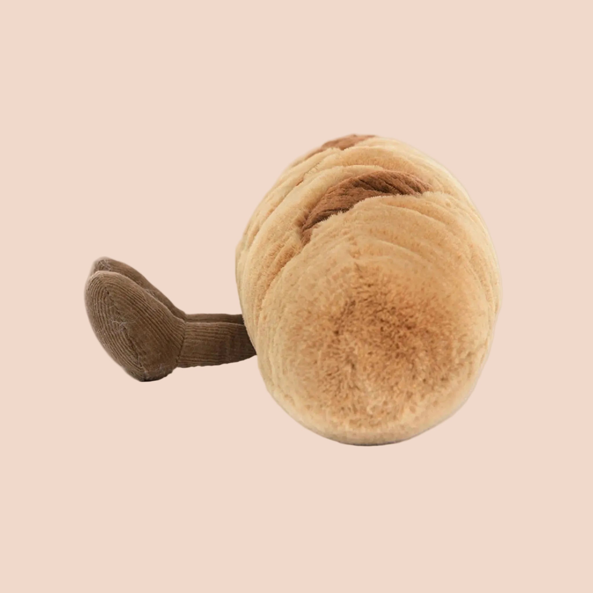 A baguette shaped stuffed toy with an adorable smiling face and brown corduroy feet. 