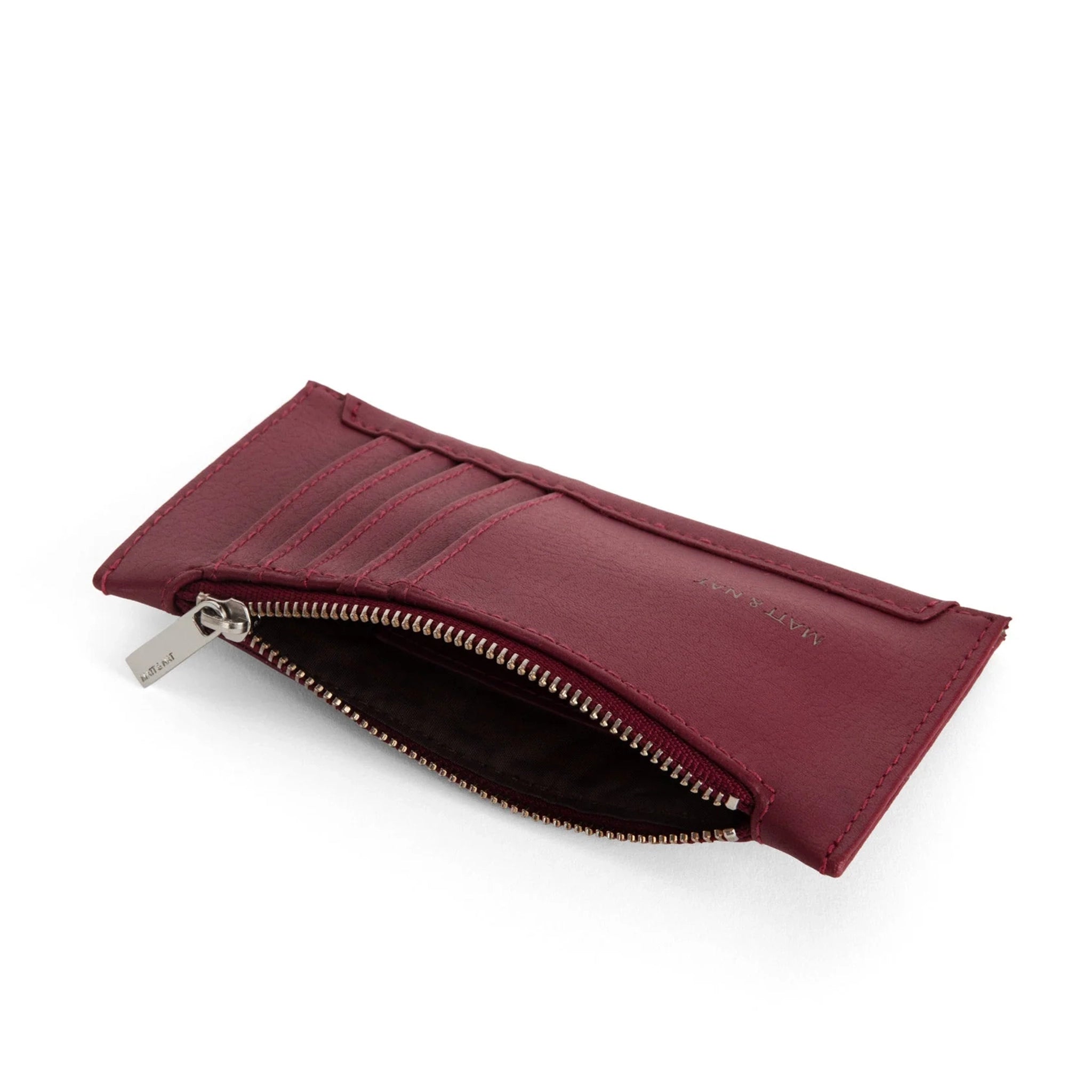 On a white background is a dark cherry red with card slots on the outside and a zipper pocket.