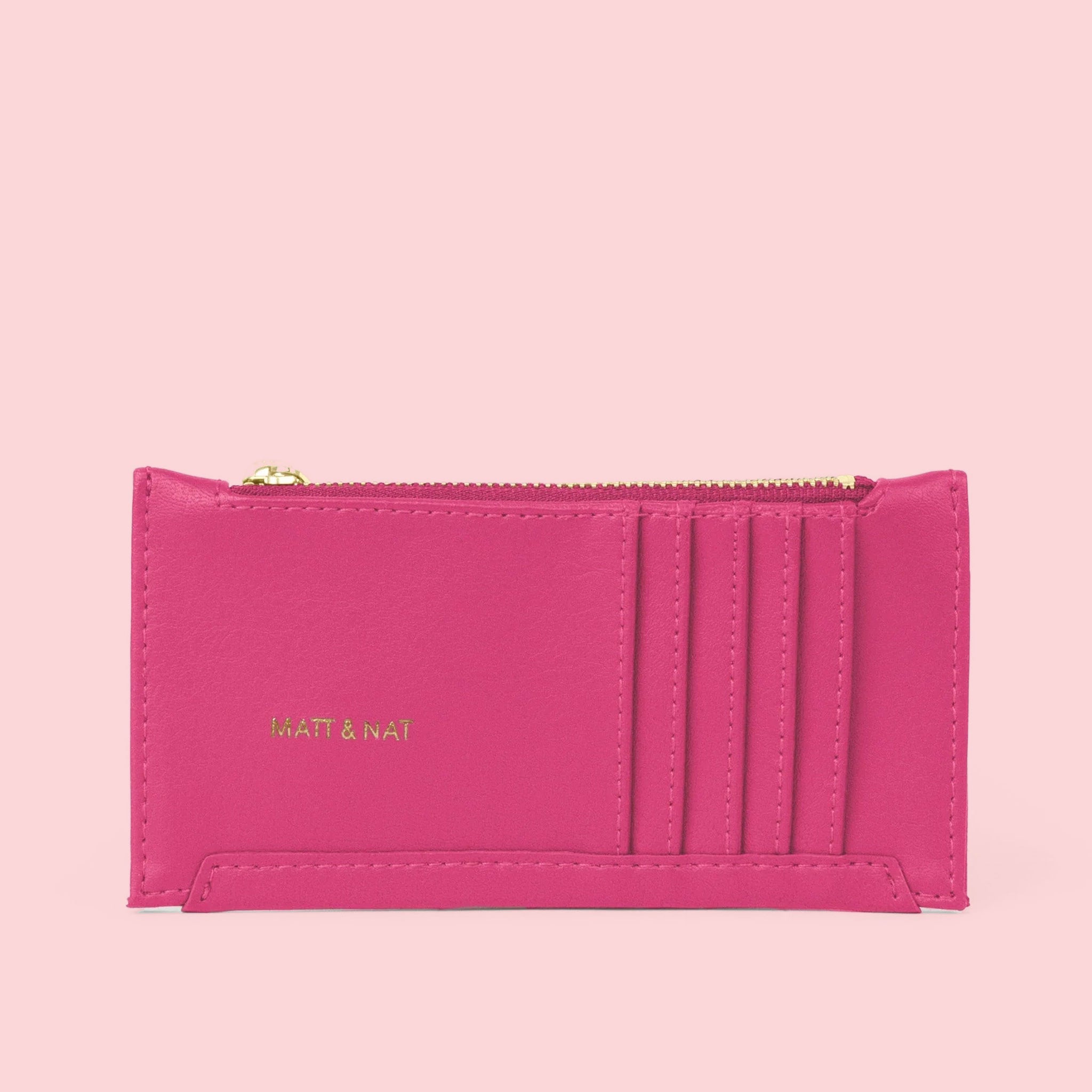 On a pink background is a hot pink wallet with card slots on the outside and a zipper.