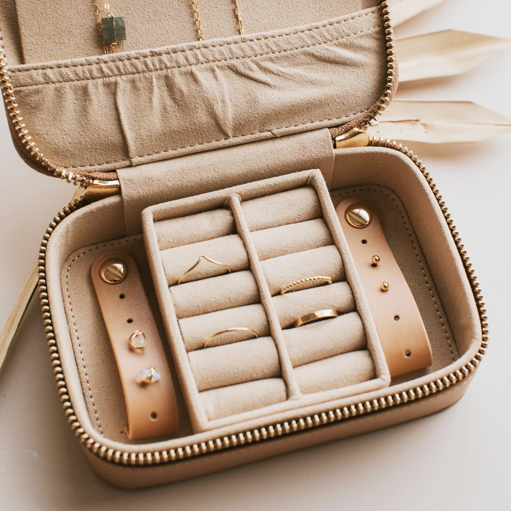 The jewelry travel case opened with two ring holders in the center and snap loop closures for earrings. 