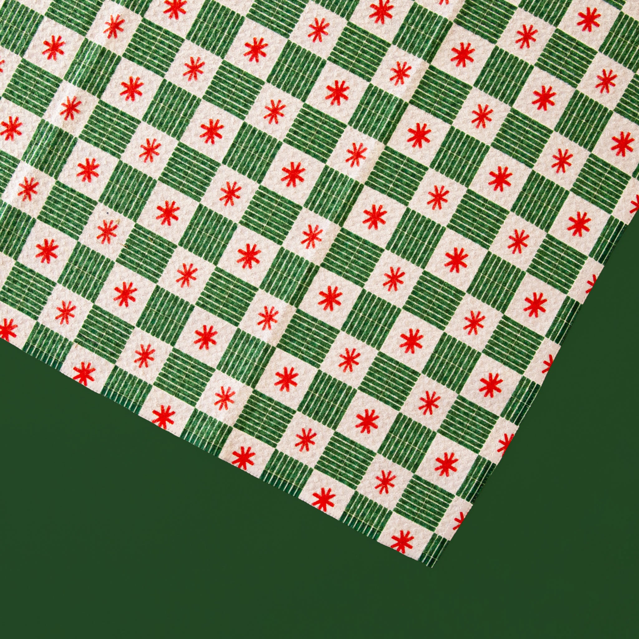 A green, red and white grid pattern kitchen towel with a waffle texture. 