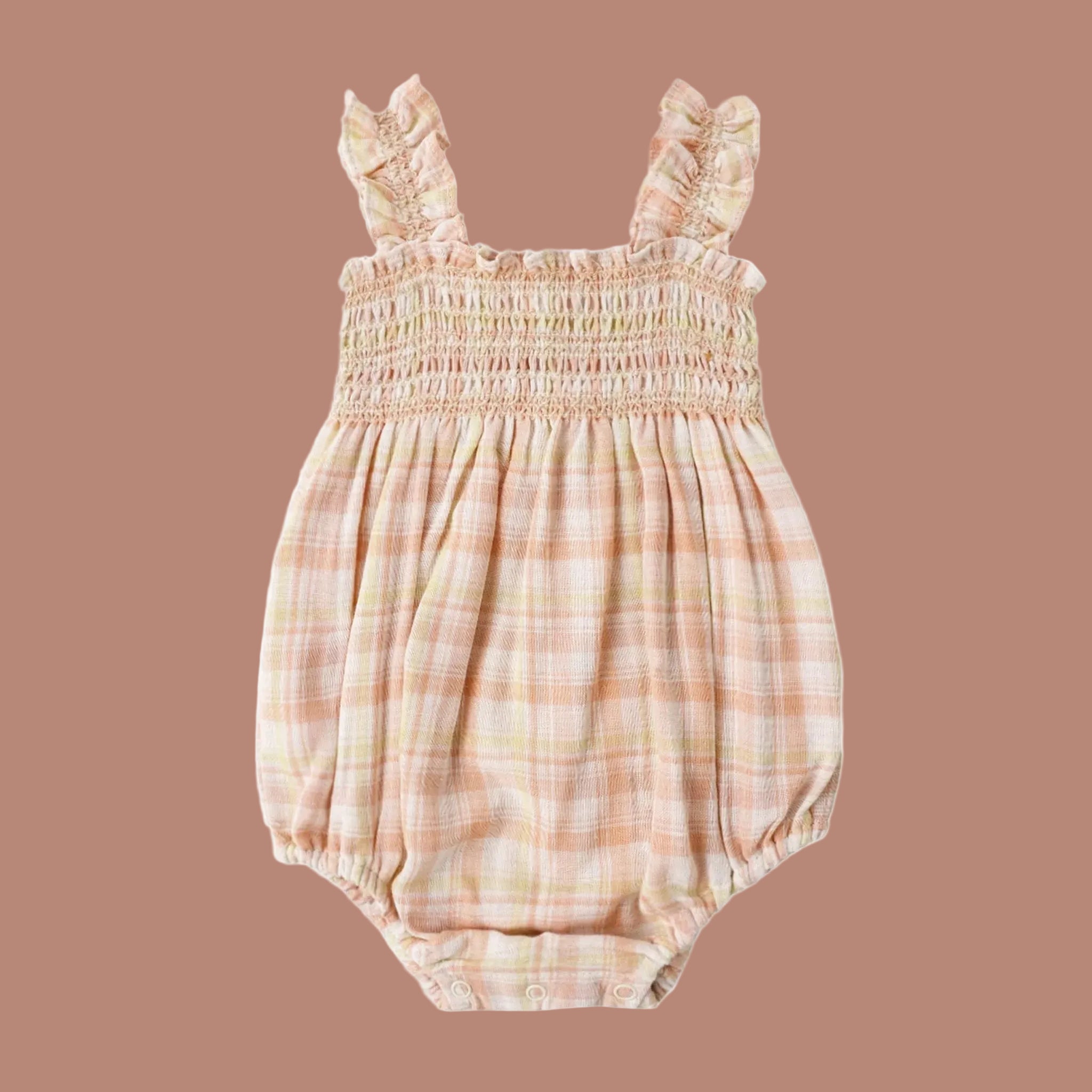 A light tan, pink plaid romper with a ruffle shoulder strap detail. 