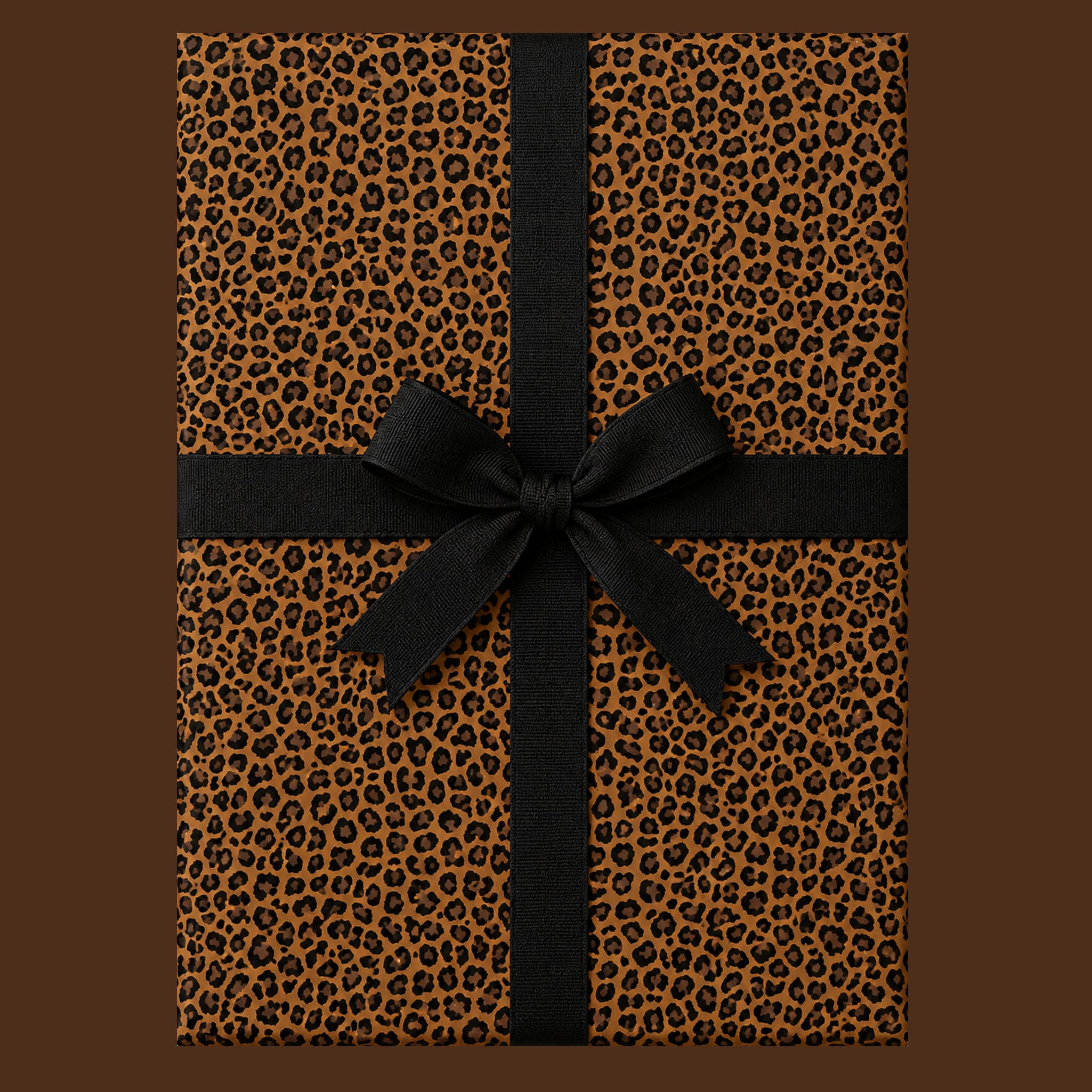 Leopard print wrapping paper wrapped present on a brown background with a black ribbon bow.