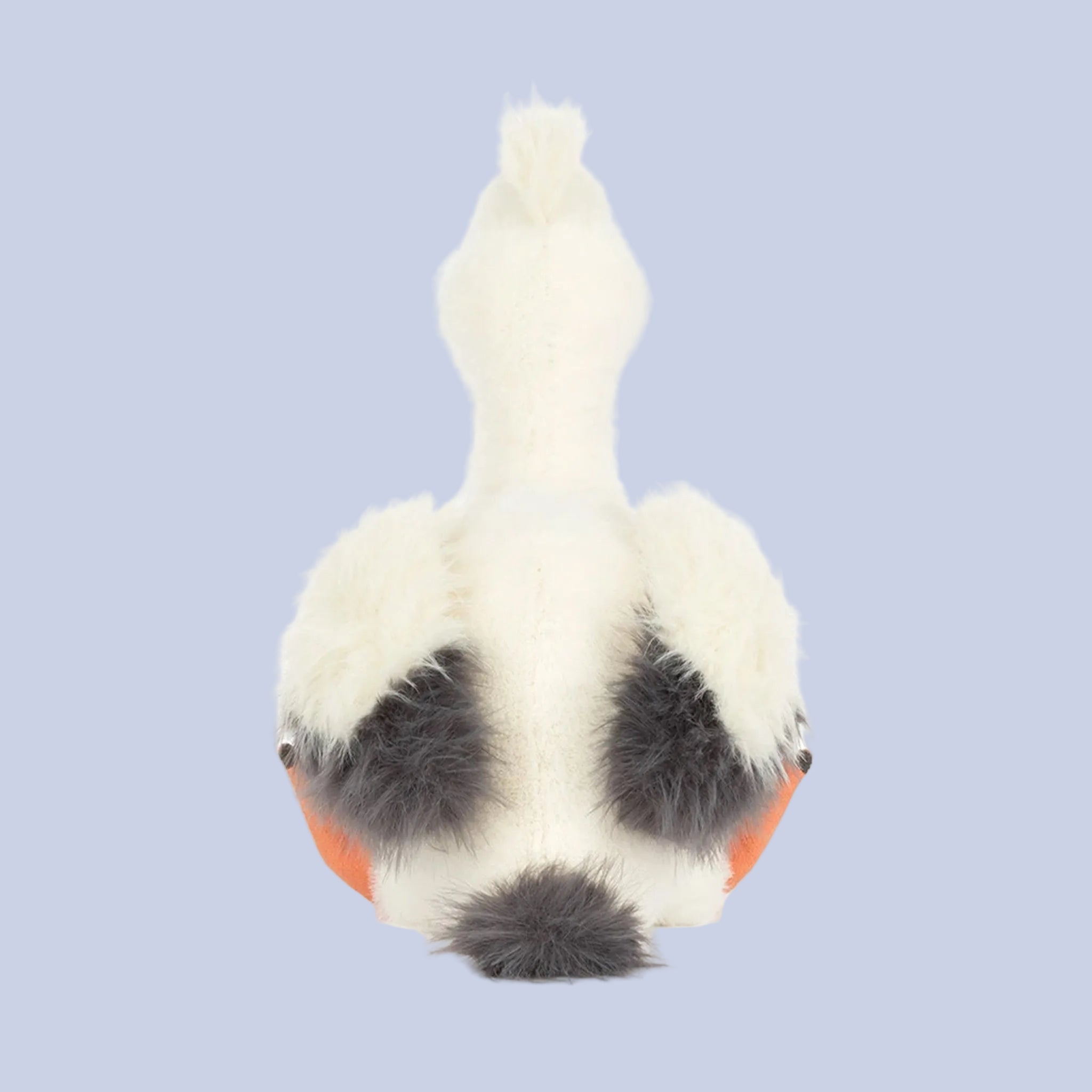 Small plush toy with a white body, black spots, and an orange bottom on a white background
