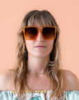 70's inspired square sunglasses with an oversized cognac colored frame and a brown lens.