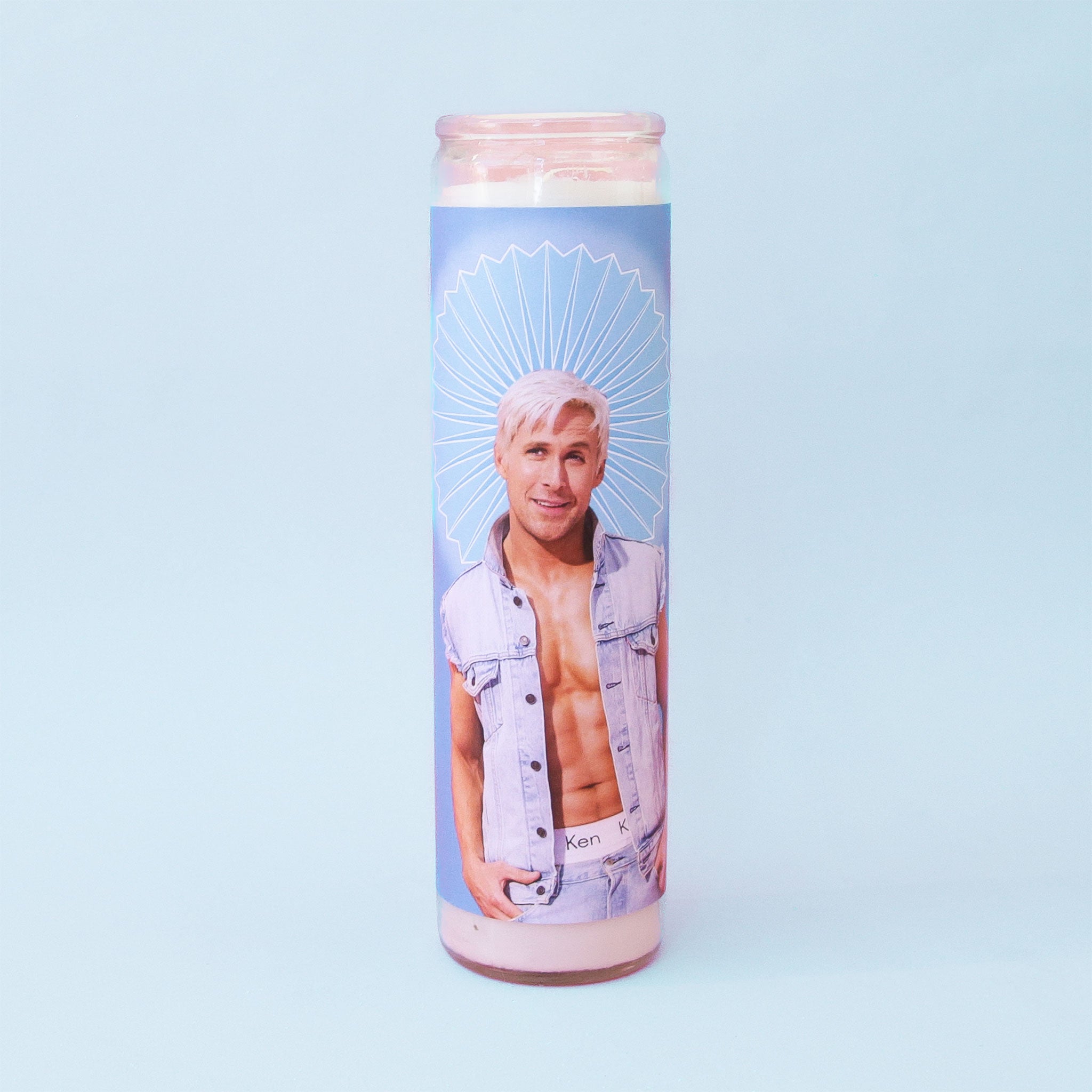On a blue background is a blue prayer candle with a photo of Ken played by the actor Ryan Gosling.