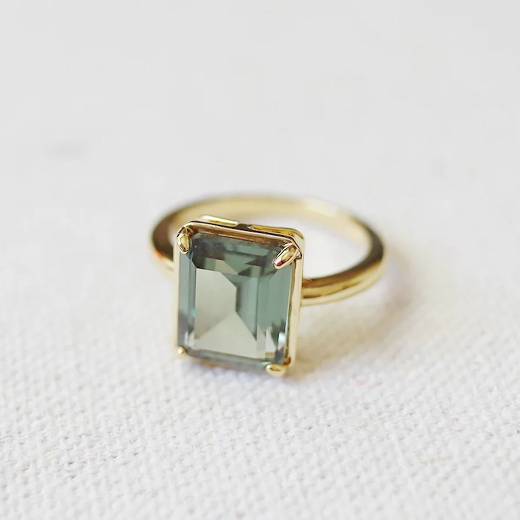 A gold ring with a tourmaline stone in the center. 