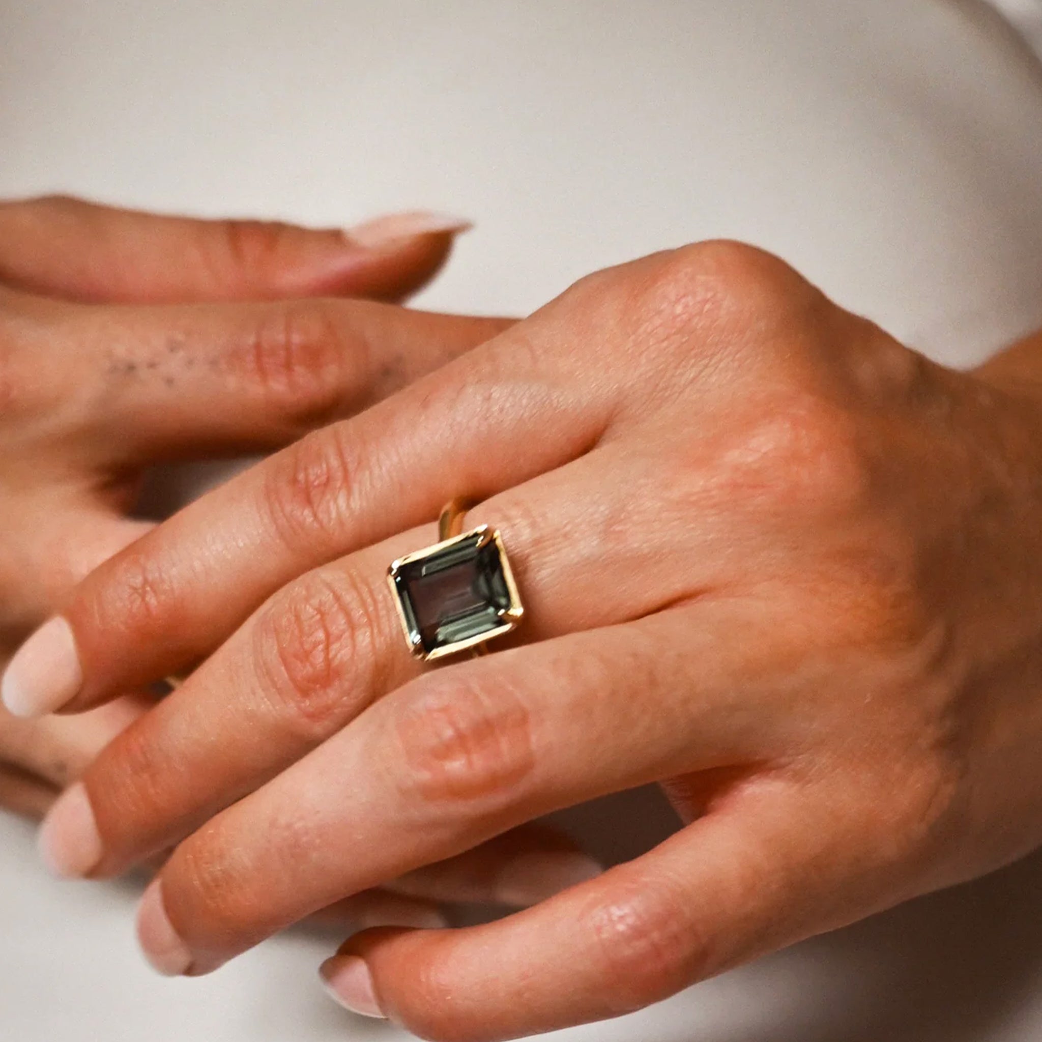 A gold ring with a tourmaline stone in the center. 
