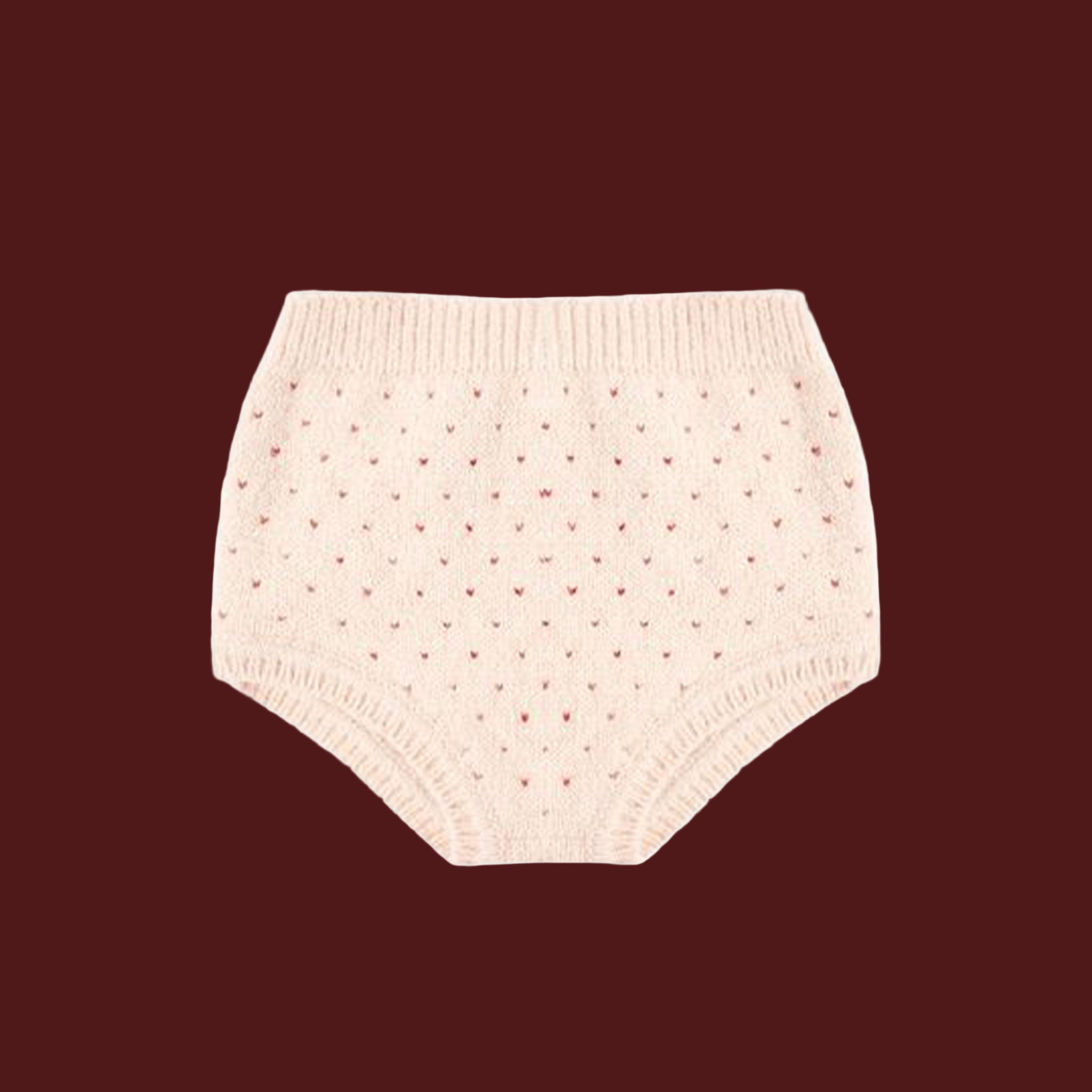 A pair of light pink knit bloomers with tiny red hearts. 