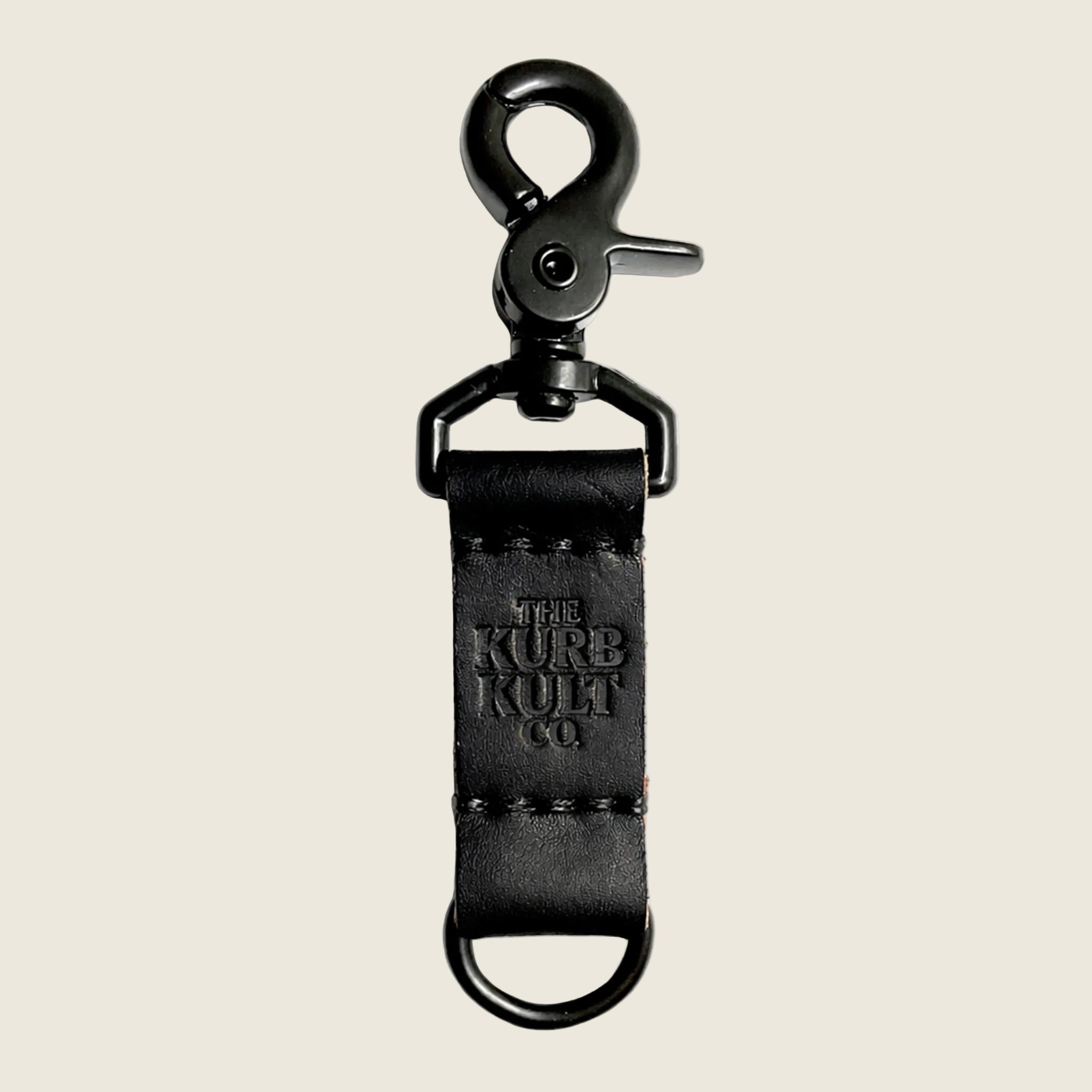 "The Kurb Kult Co." embossed on a black leather keychain. 