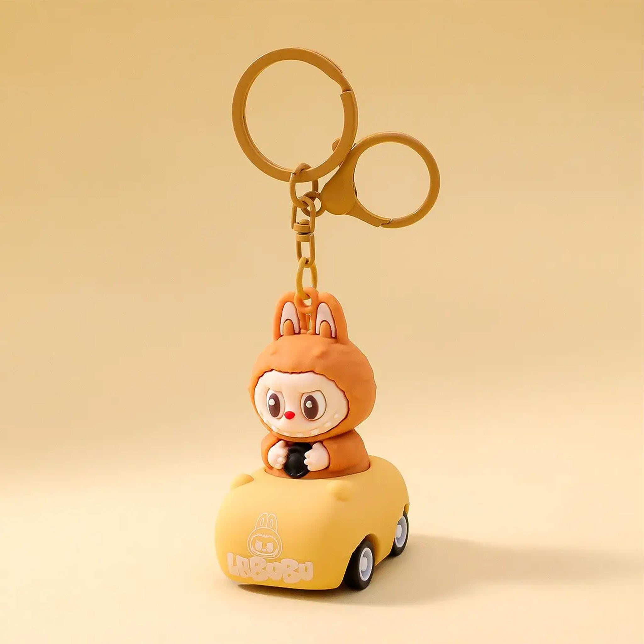 A brown labubu in a car shaped keychain. 