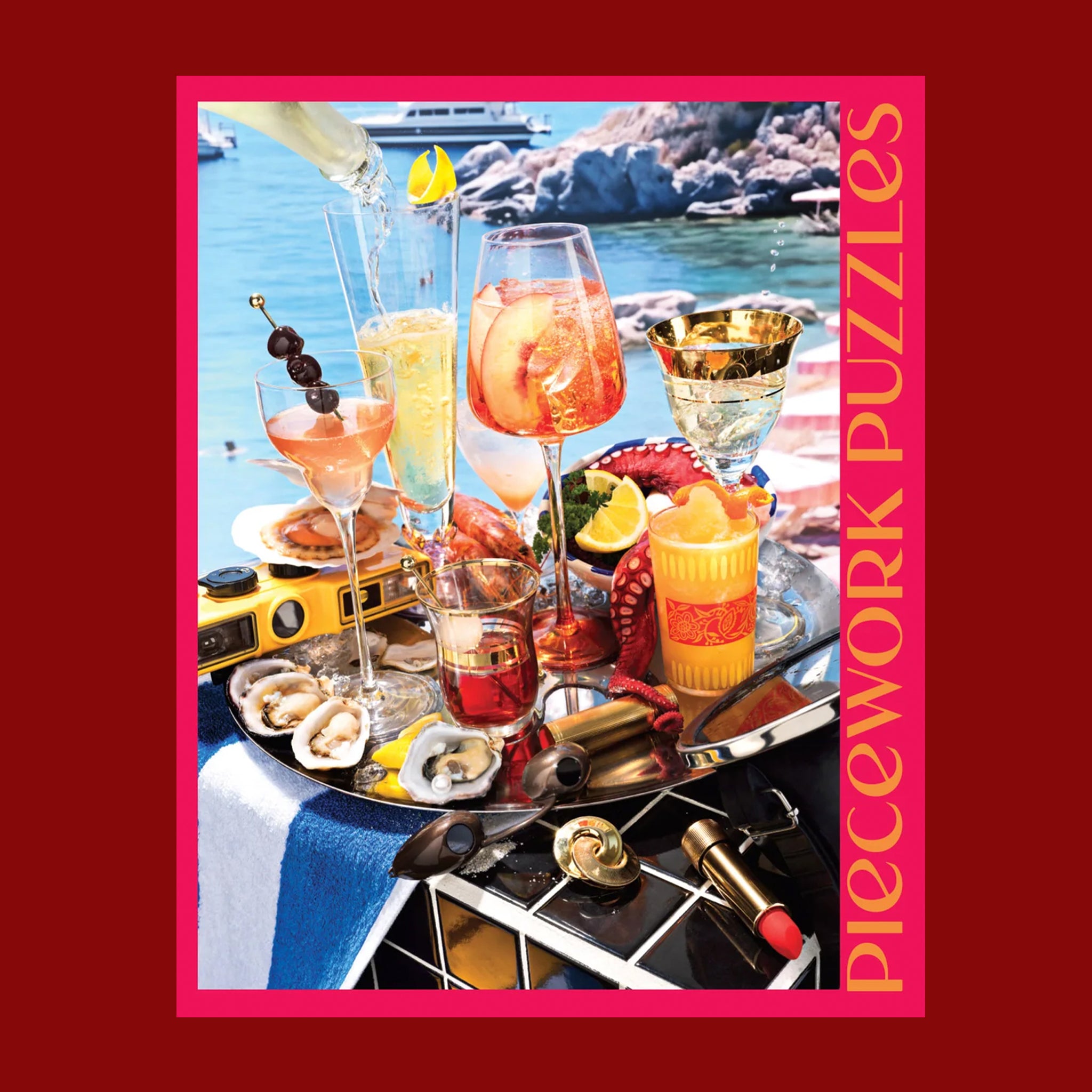 A hot pink puzzle box with an image of a beachside drinks tray with a variety of cocktails and beachside essentials.
