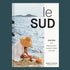 A book cover with a photo of someone cutting fruit on rocks next to the ocean and black text that reads, 'le sud Recipes from Province Alpes-Cote Dazur'. 