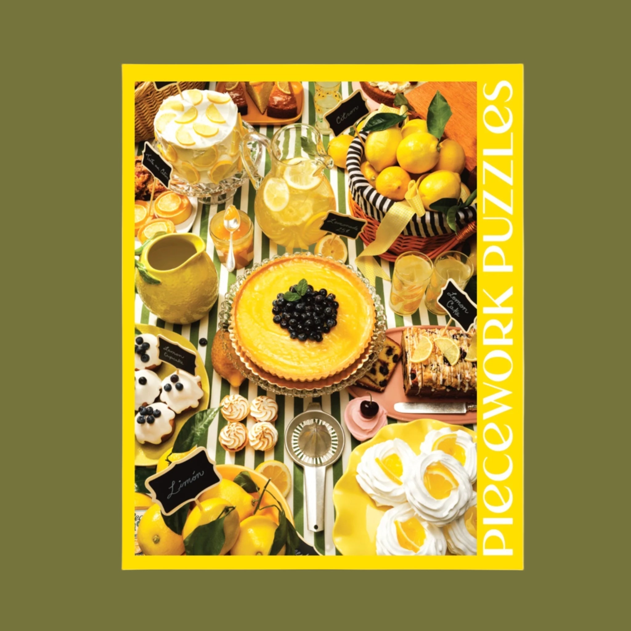 A yellow boxed puzzle that is lemon themed with a lemon food themed table scape photo and text that reads, &#39;Piecework Puzzle Lemonade&#39;. 