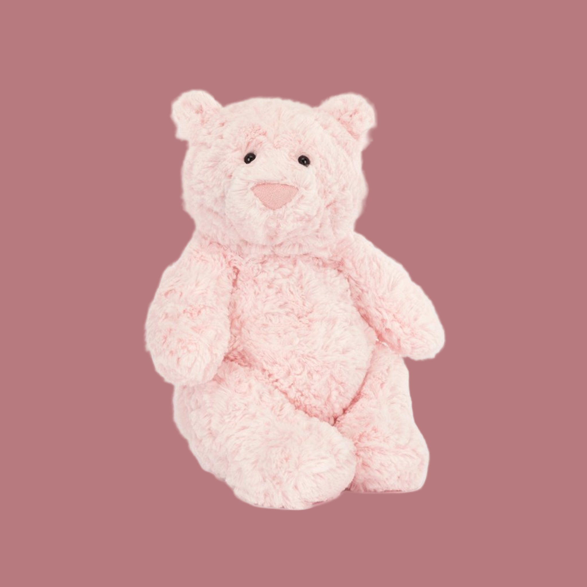 A light pink bear shaped stuffed animal toy. 