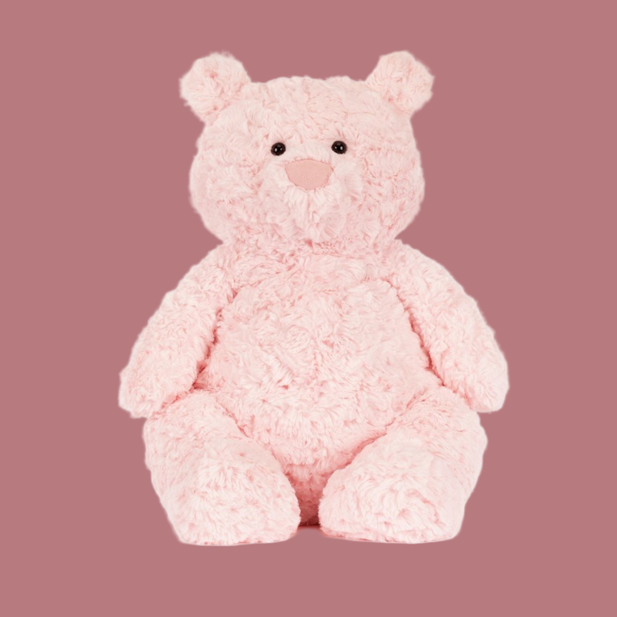 A light pink bear shaped stuffed animal toy. 