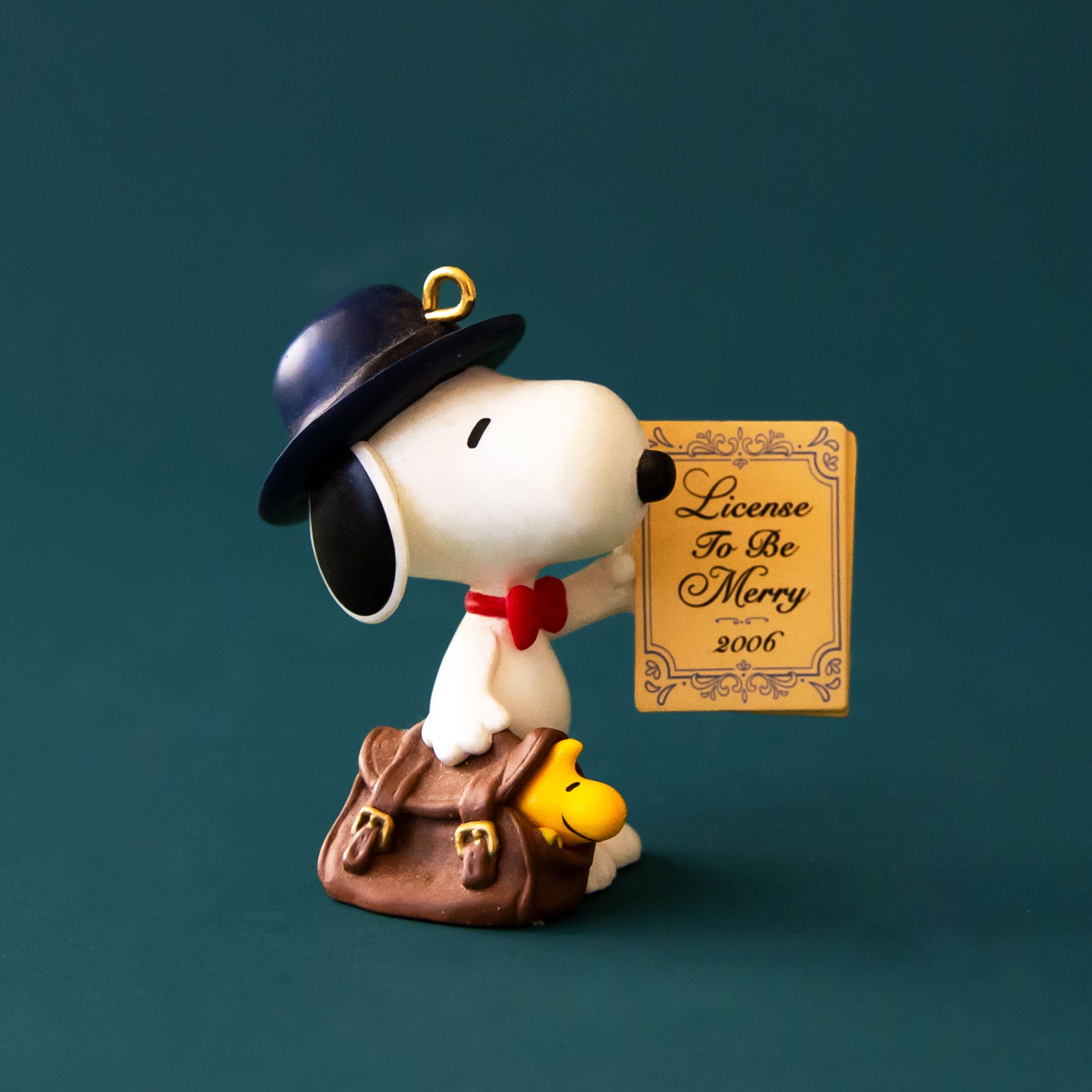 A Snoopy ornament holding a license that reads, "License To Be Merry". 