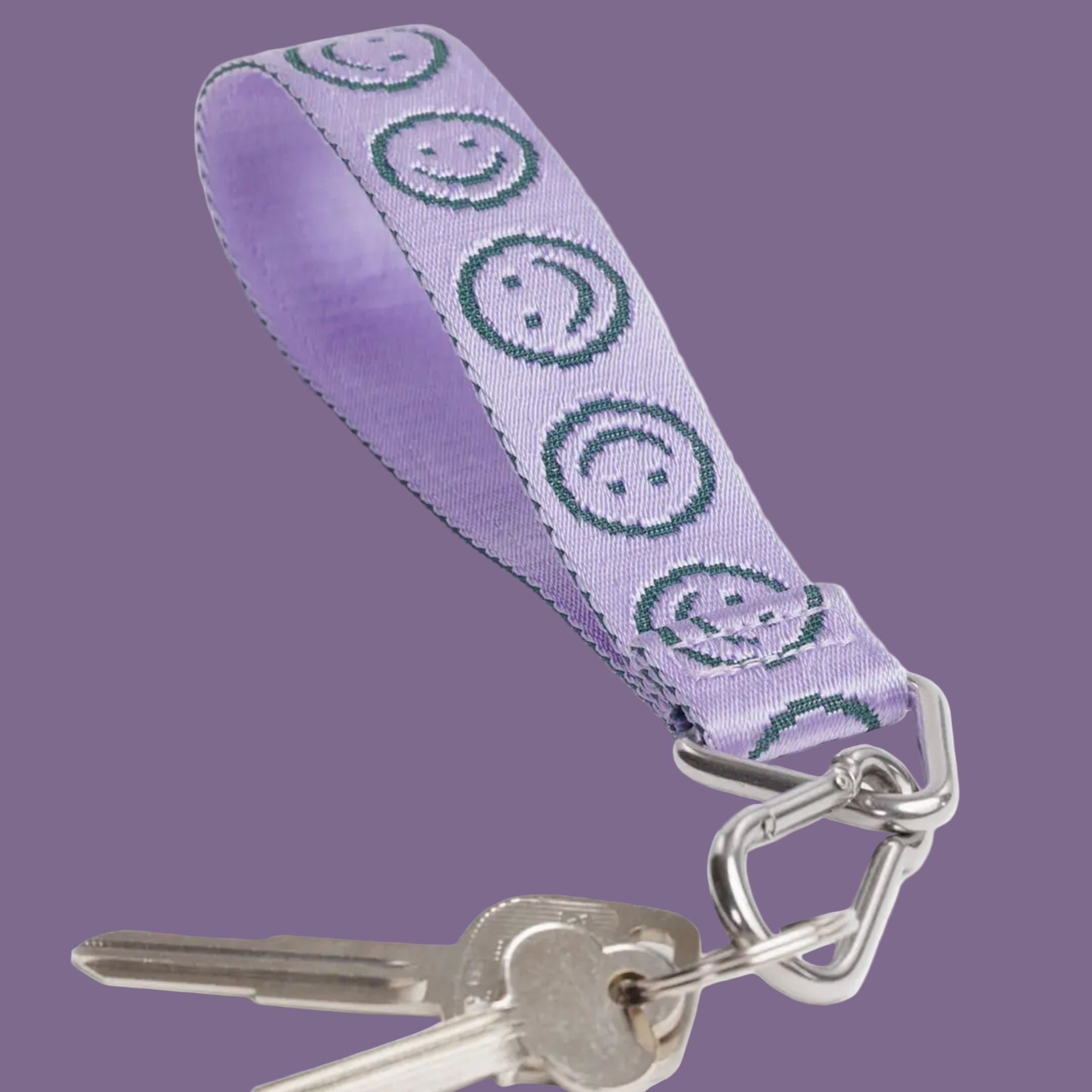 A lilac purple keychain lanyard with teal smiley faces. 