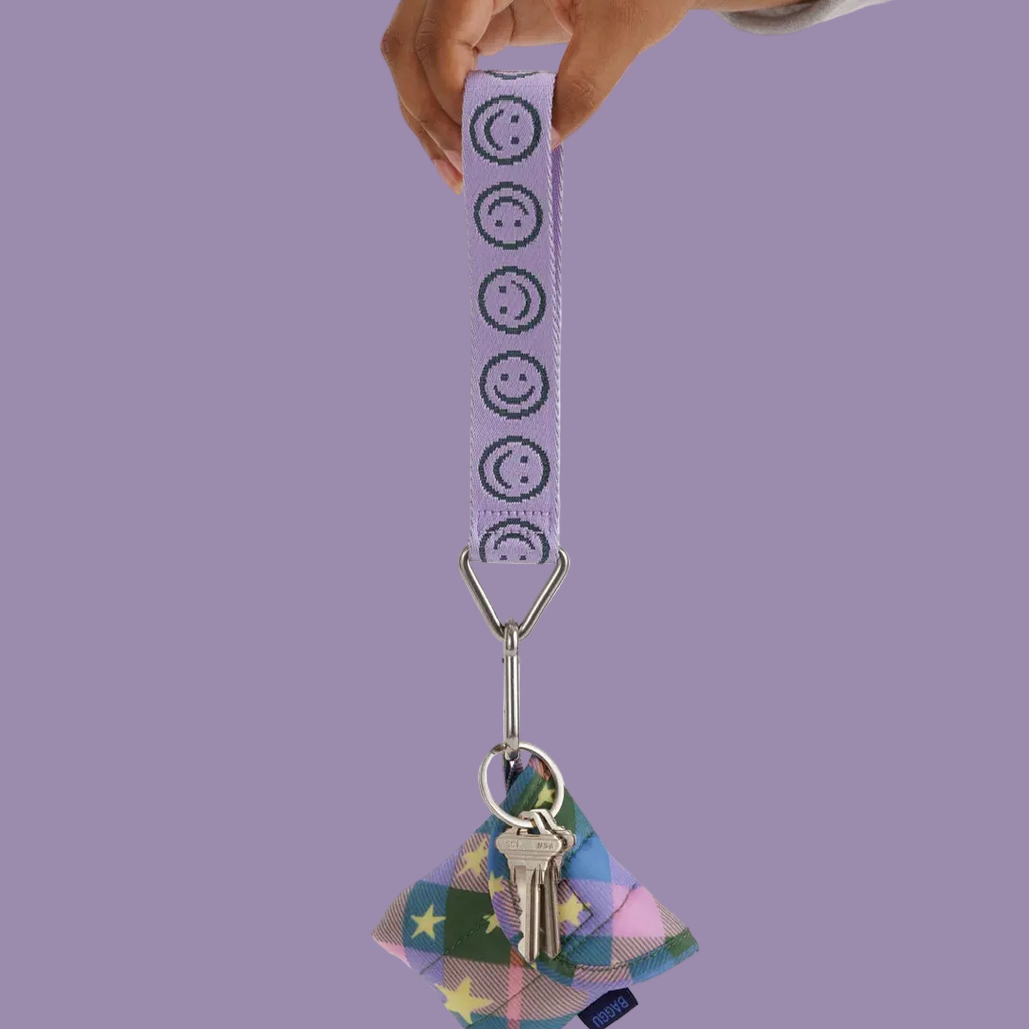 A lilac purple keychain lanyard with teal smiley faces. 