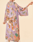 On a tan background is a lilac robe with a floral and tiger design.